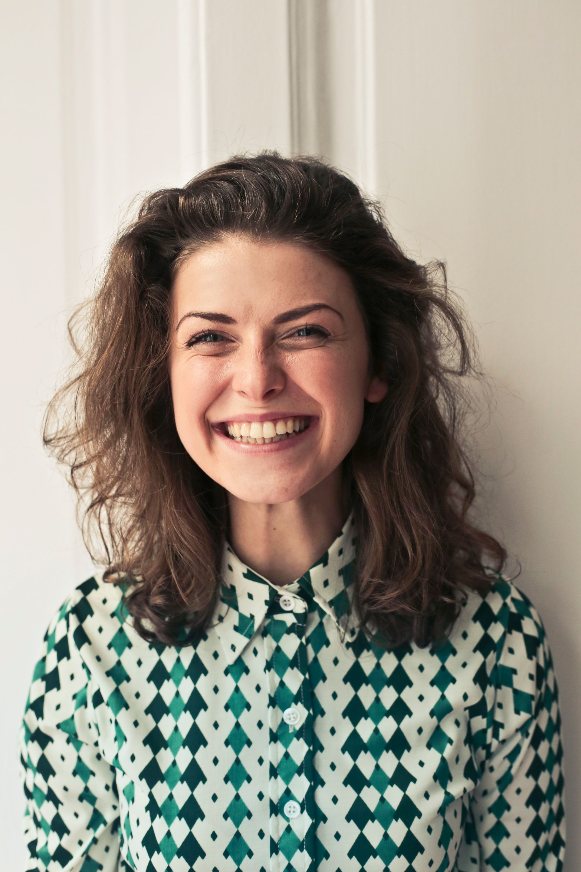 Portrait of the senior editor standing beside a bookshelf with notebooks